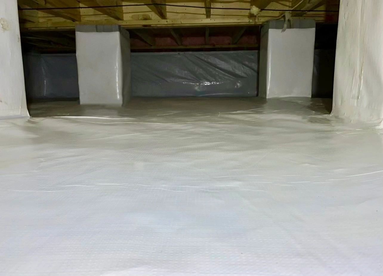 Sealed ground and wrapped piers under a wide low ceiling.