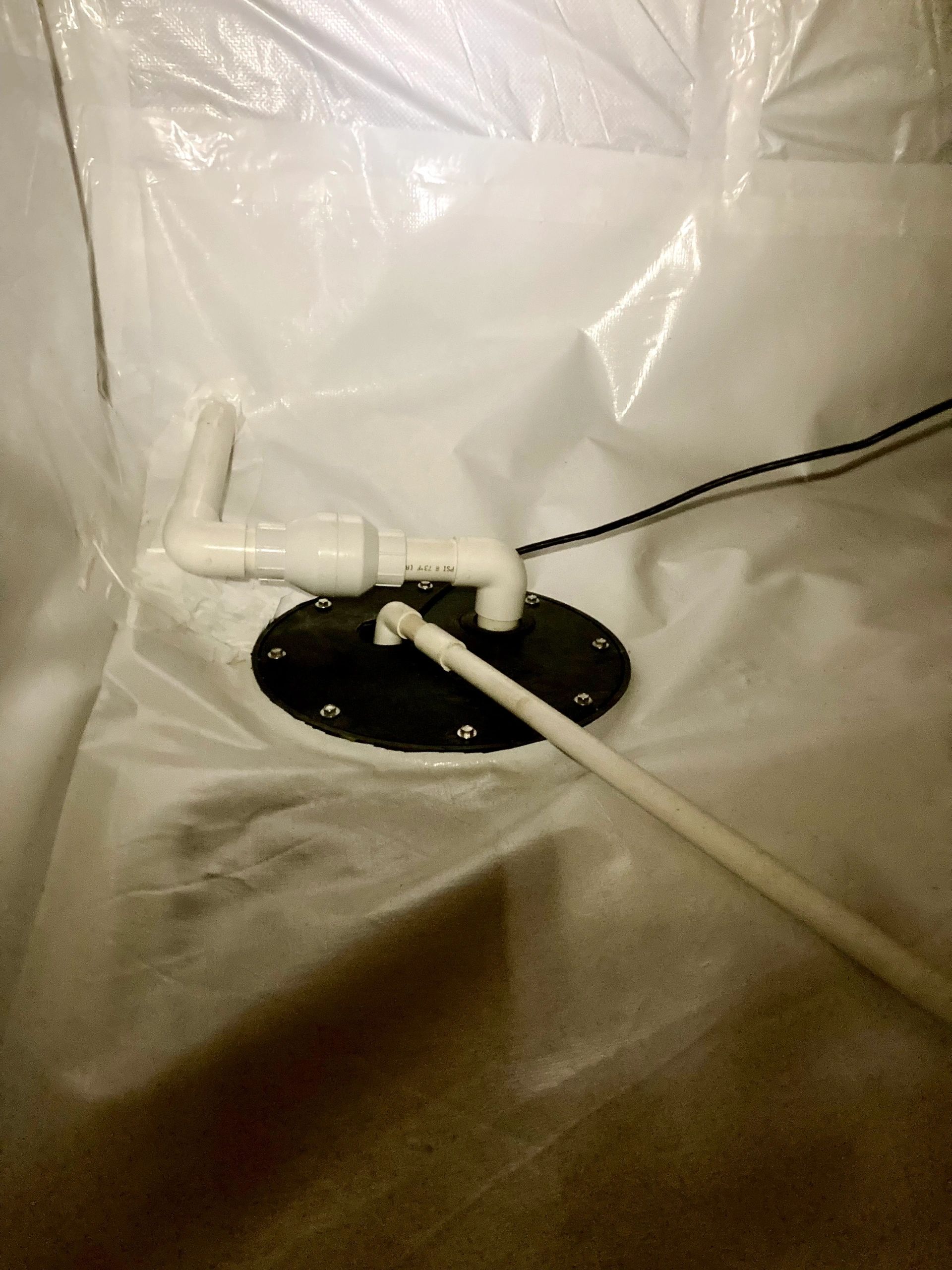 A sump set into the sealed floor, its lines run out through the liner.