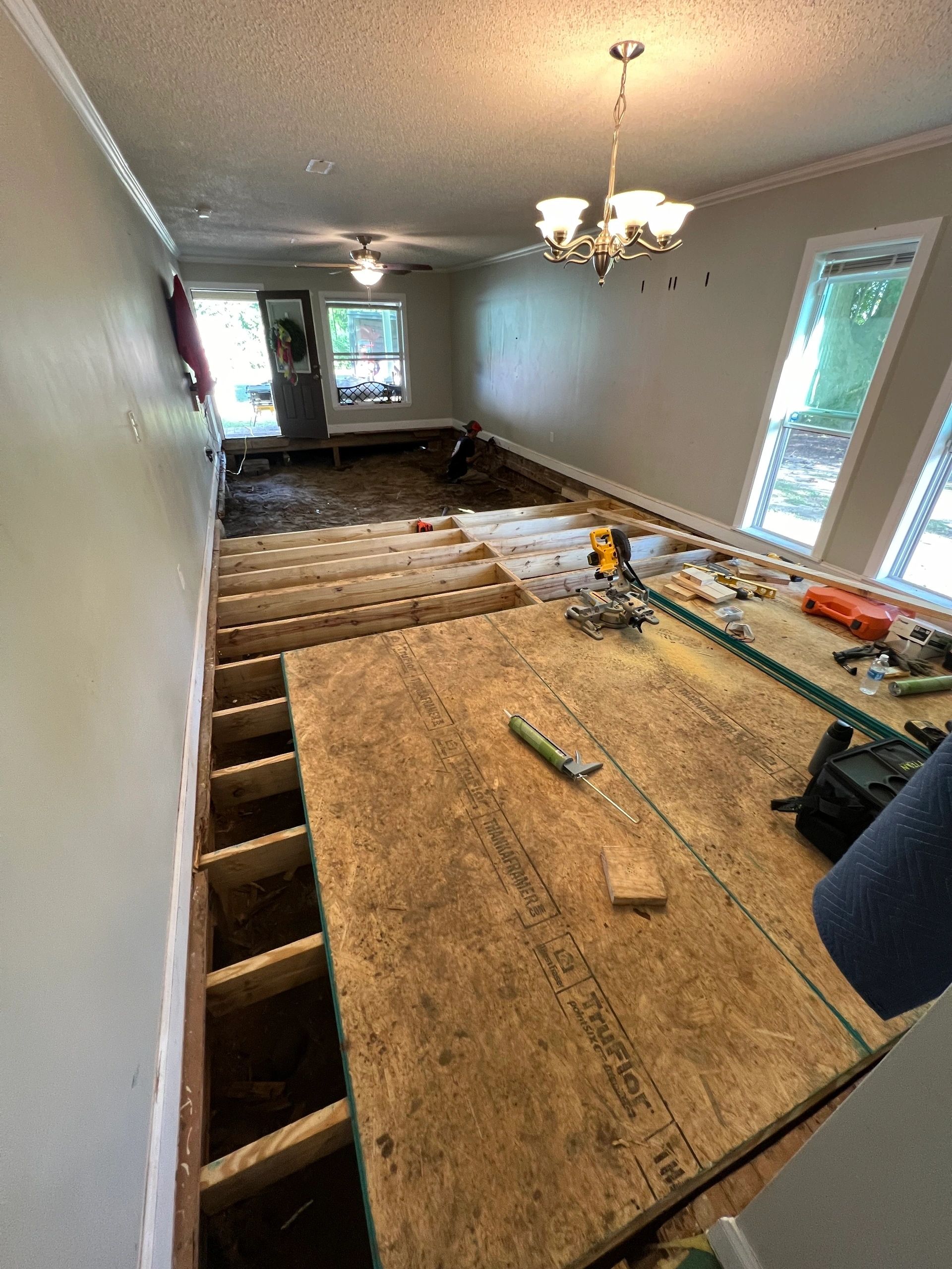 A dining room floored back to solid, the fitting still hanging above.